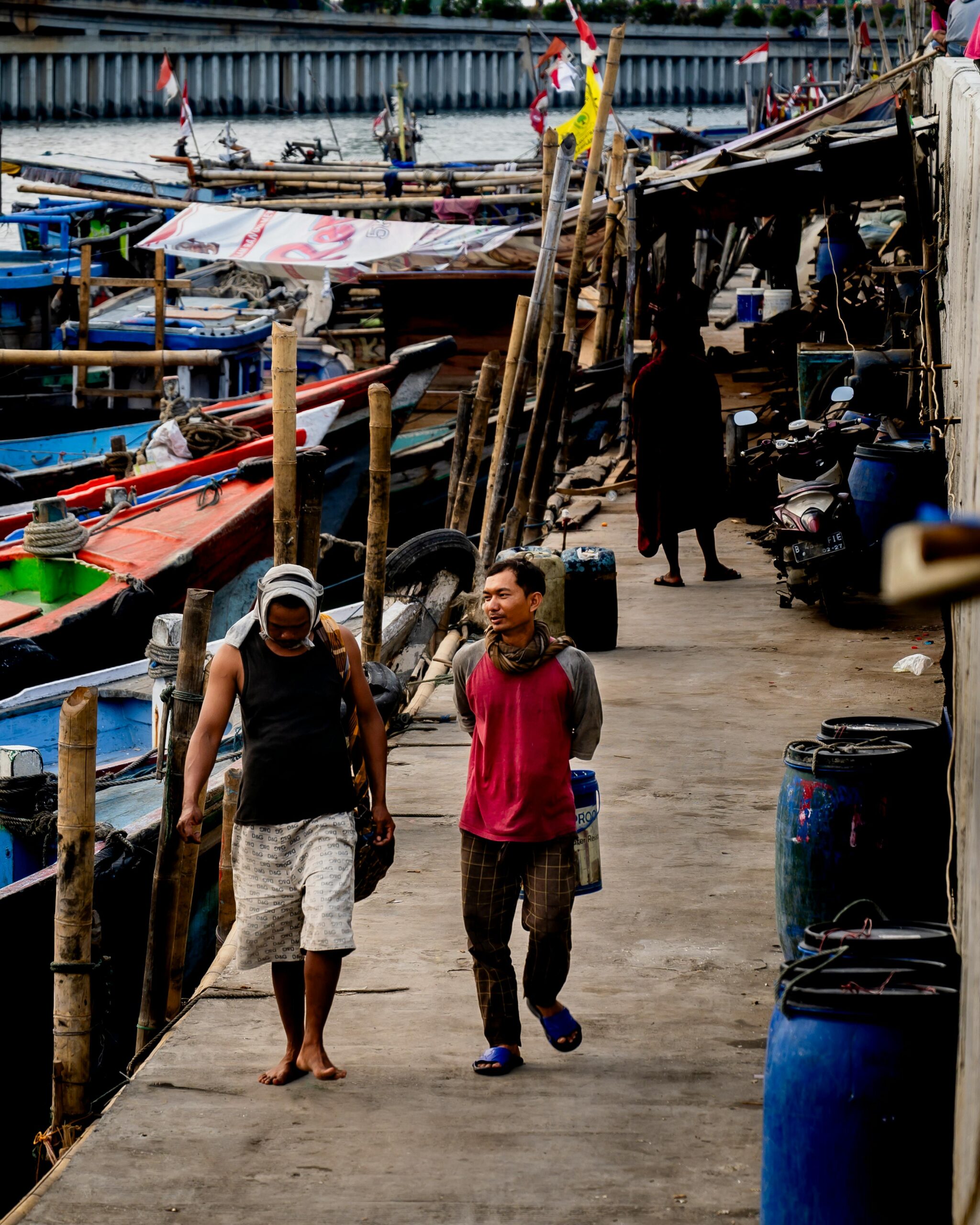 Two men walking along a dock in Jakarta